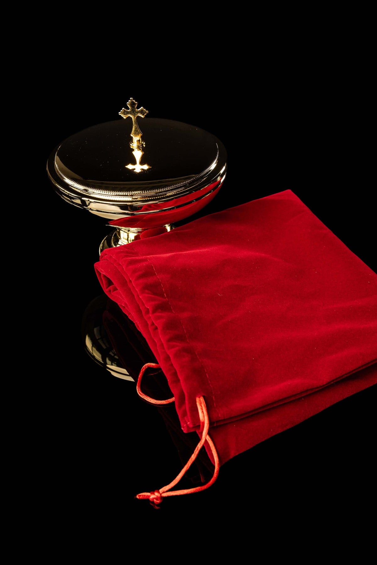 Złota puszka liturgiczna z krzyżem i czerwonym etui, widok z boku