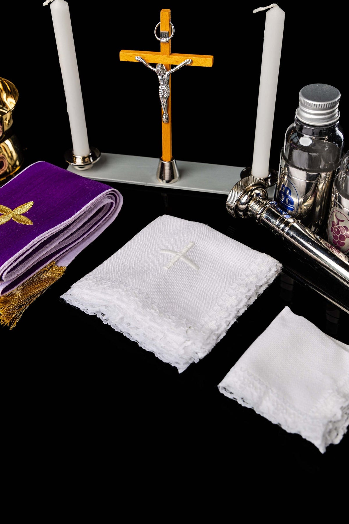 Fioletowy welon, krzyż i białe koronki z wyposażenia walizki liturgicznej