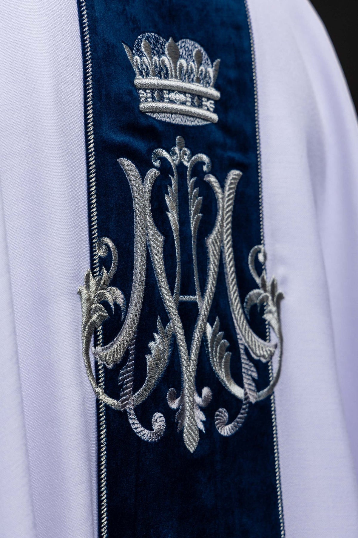 Biały ornat maryjny z ukoronowanym monogramem Maryi, zbliżenie haftu na plecach