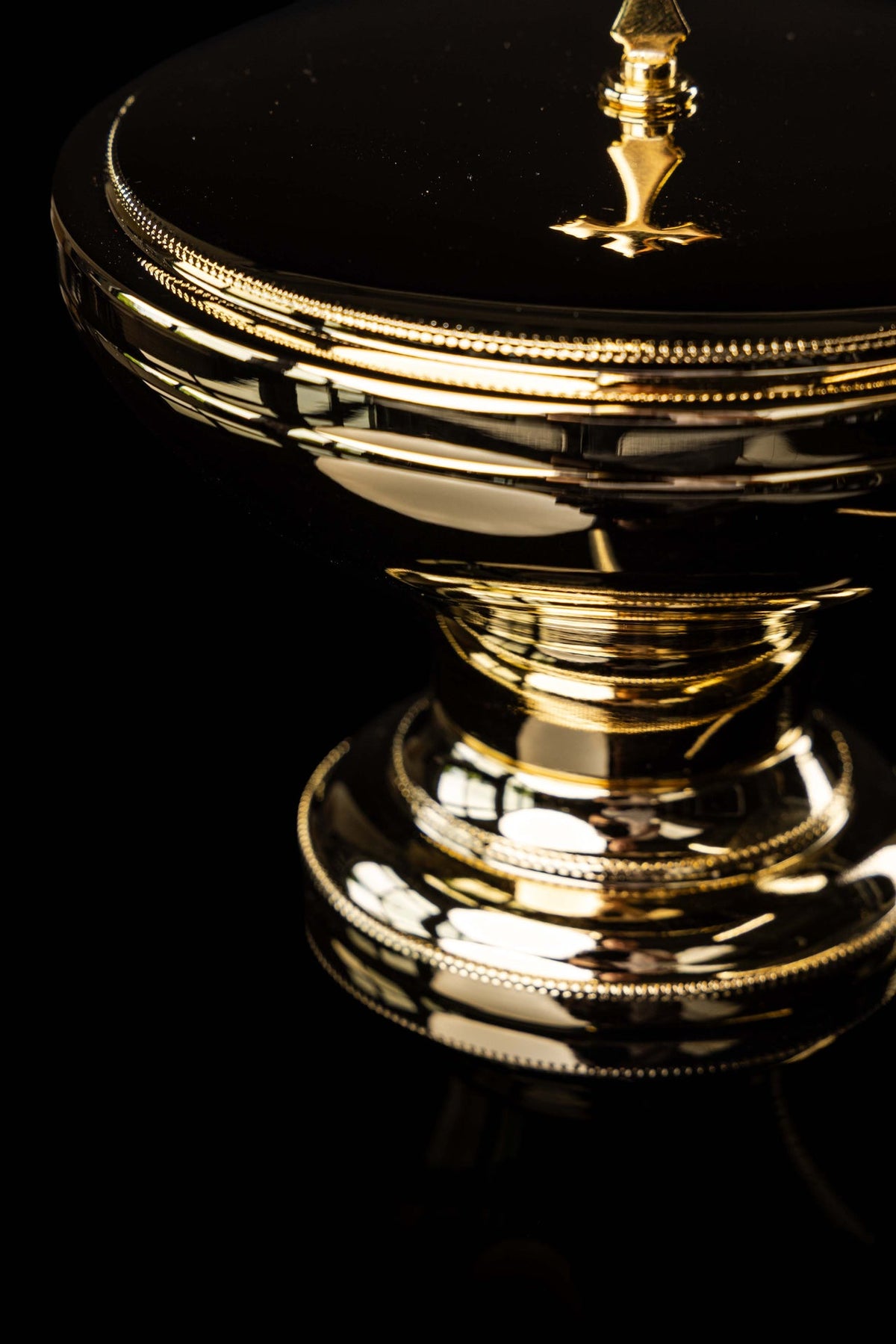 Złota puszka liturgiczna z krzyżem, zbliżenie pokrywy i podstawy