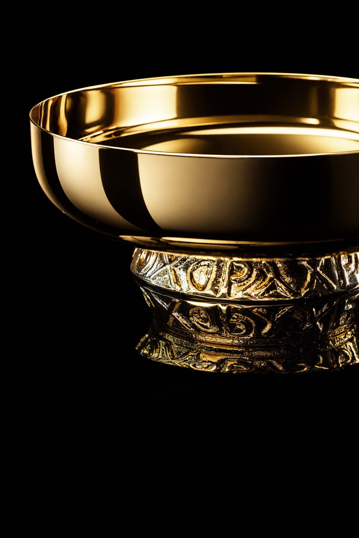 Złota patena liturgiczna do koncelebry z ornamentowaną stopką, zbliżenie z boku
