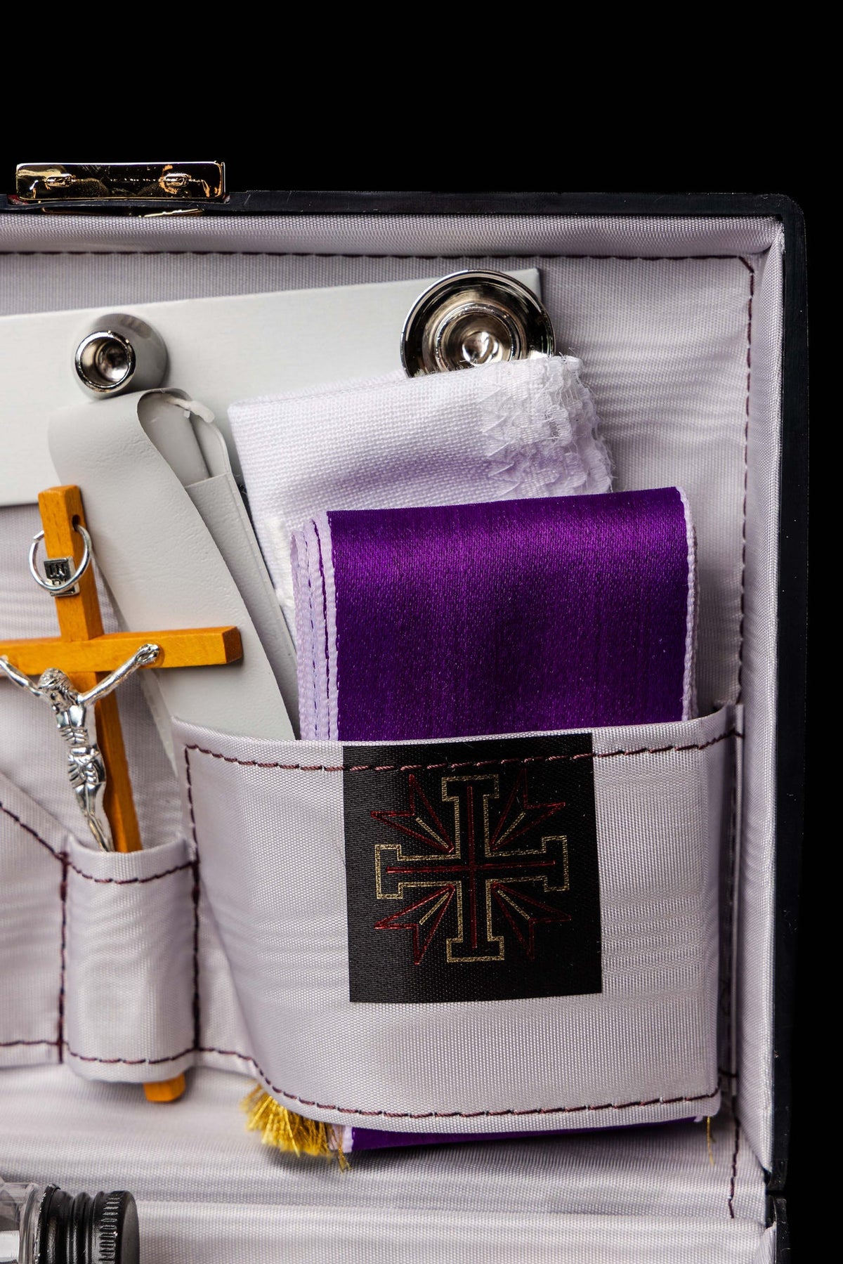 Fioletowy welon i biała korpora w walizce liturgicznej, zbliżenie