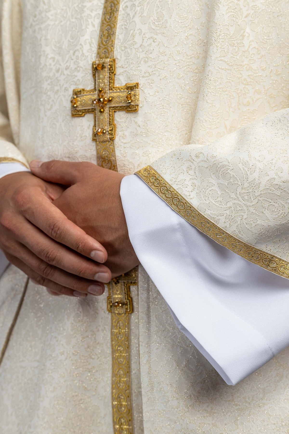 Ecru ornat eucharystyczny z krzyżami i kamieniami, zbliżenie pasa centralnego