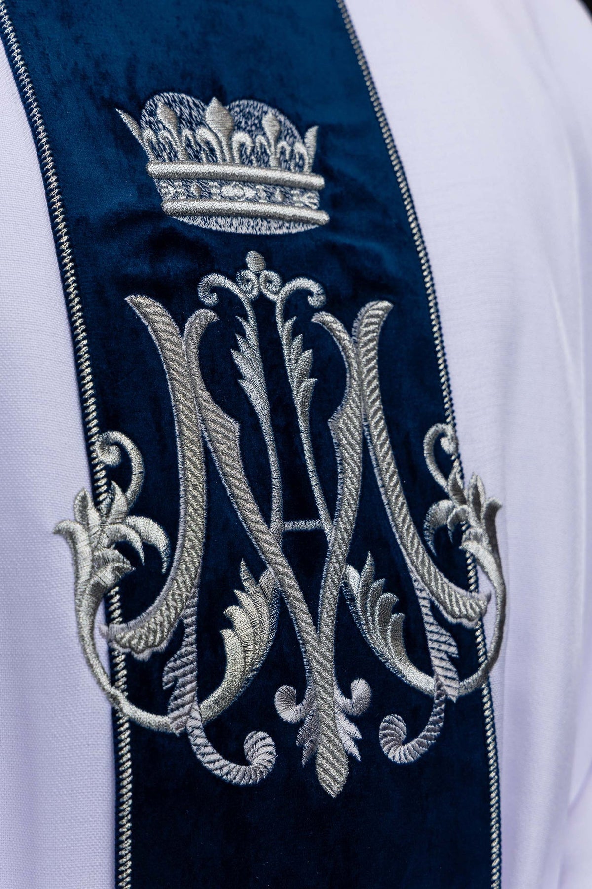 Biały ornat maryjny z haftowanym monogramem Maryi i koroną, zbliżenie przodu