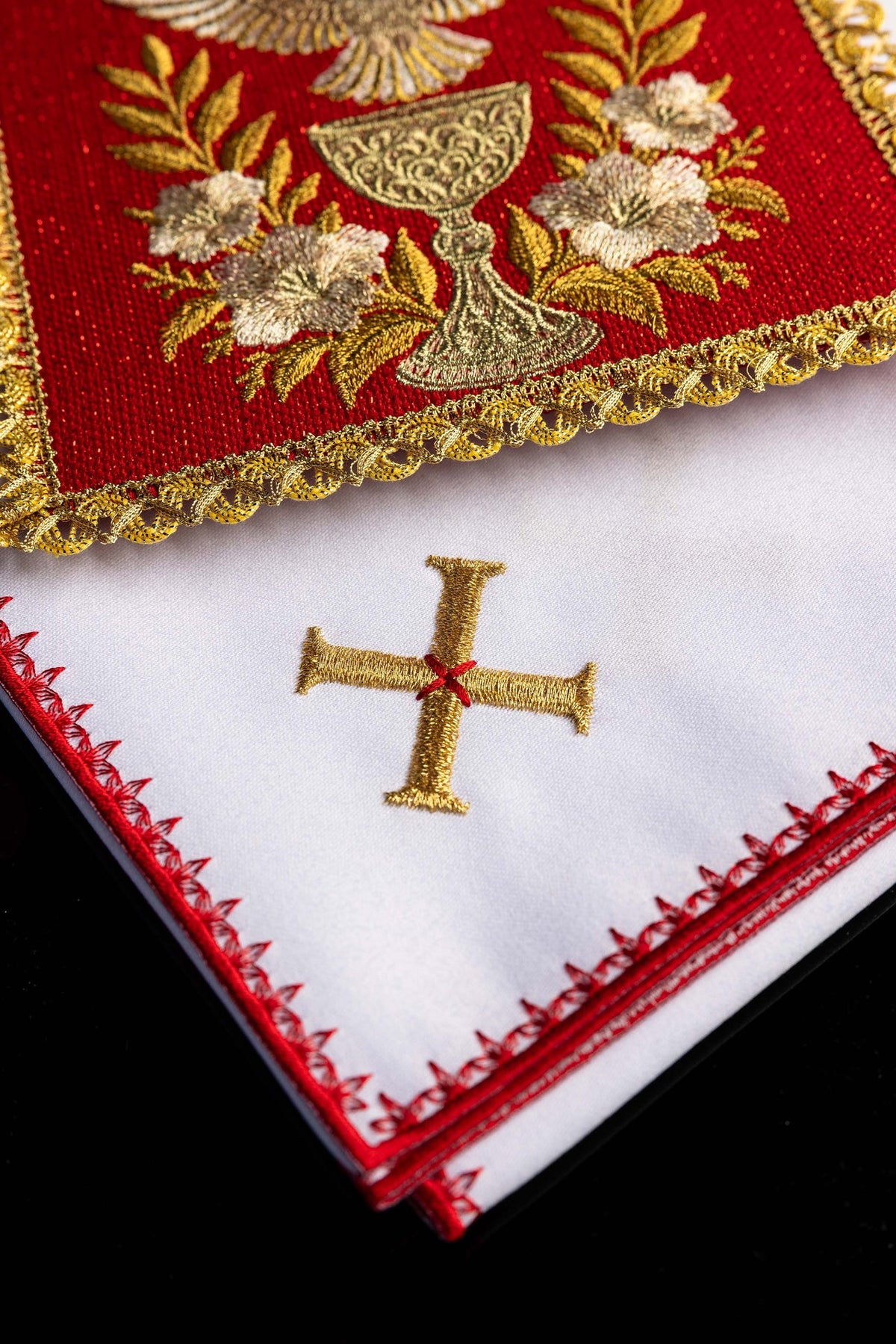 Biała bielizna kielichowa z haftowanym krzyżem i czerwonym wykończeniem, zbliżenie